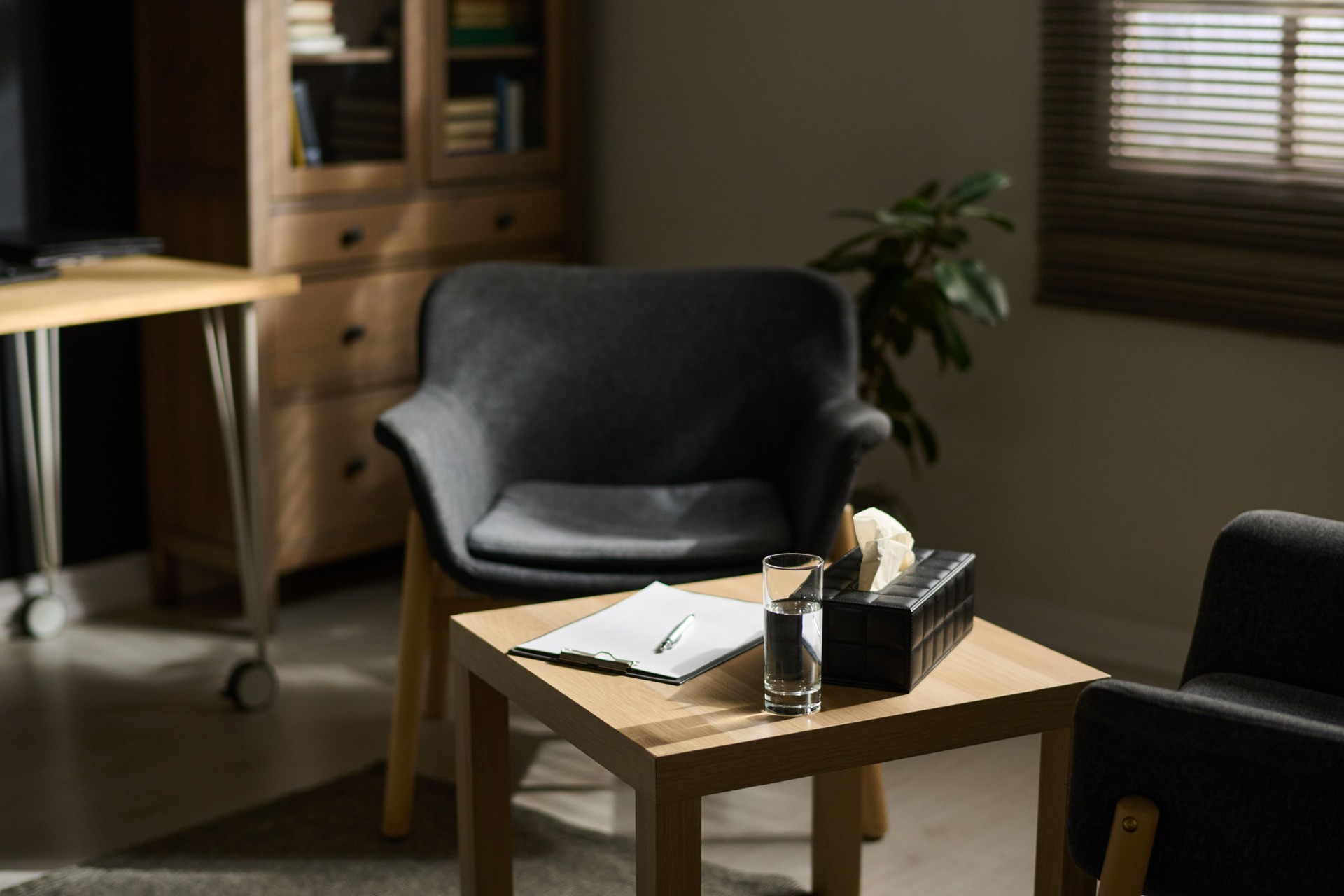 Part of office of psychotherapist with small table and two armchairs